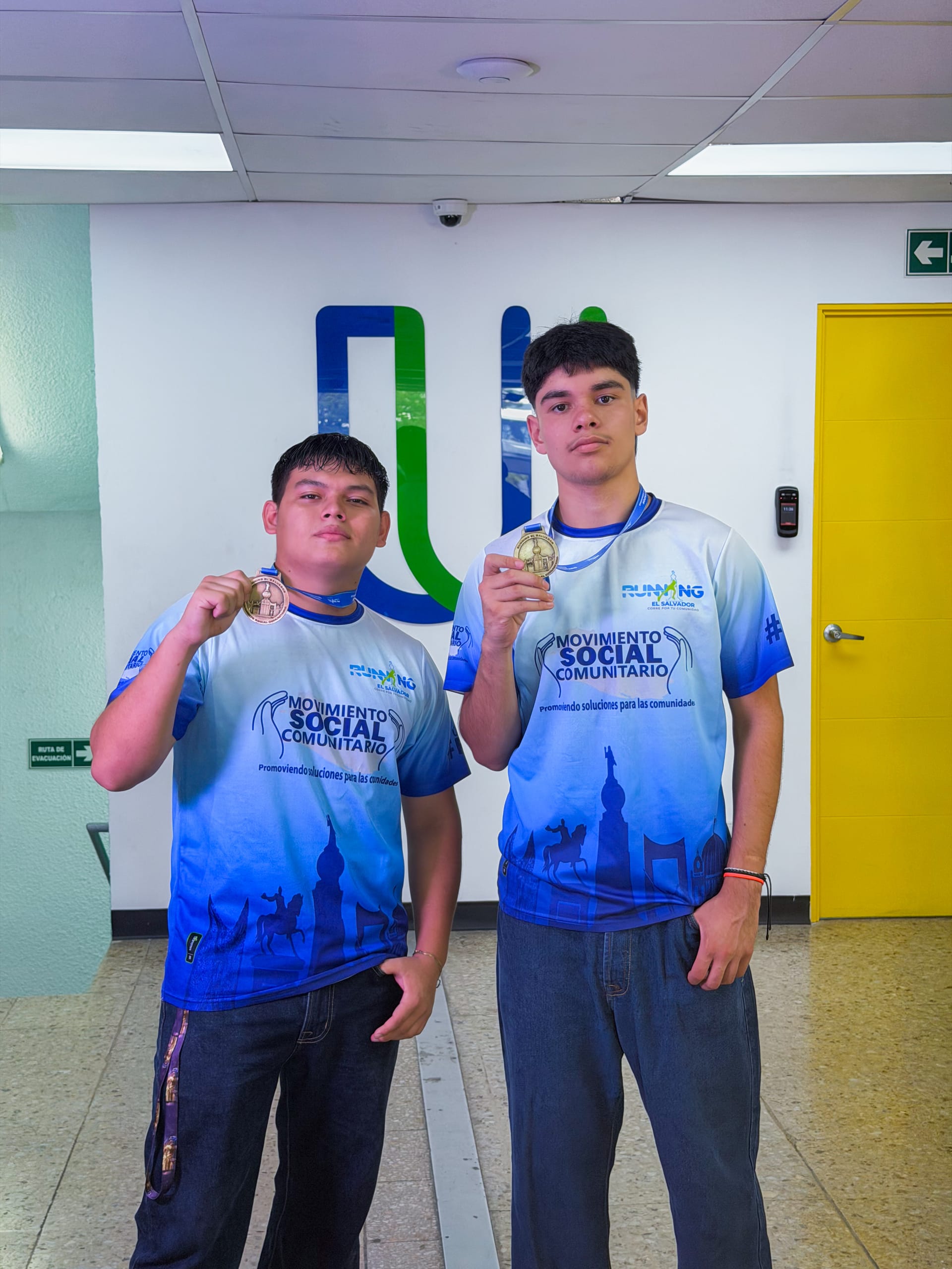 Estudiantes atletas mostrando las medallas de una carrera comunitaria