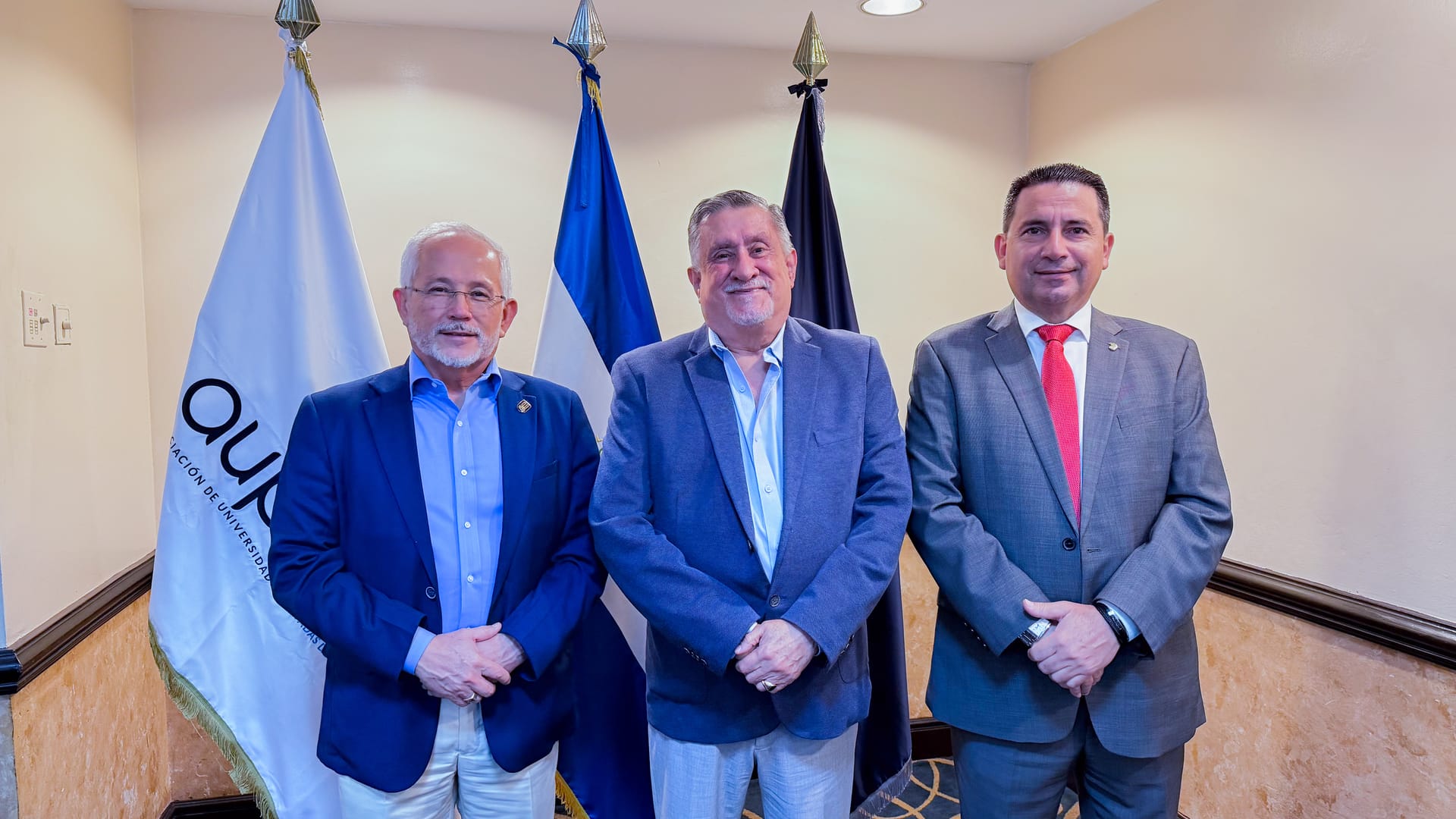 Directivos de la UPES posando con las banderas institucionales