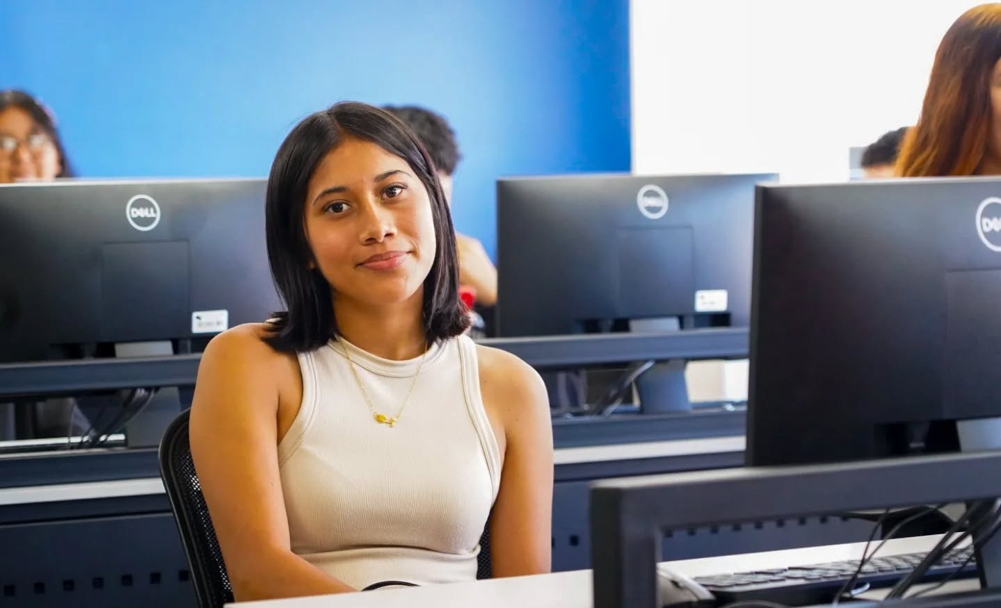 Estudiante sonriendo en el laboratorio de cómputo