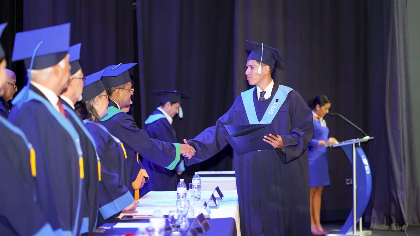 Un graduando estrecha la mano de las autoridades durante la ceremonia