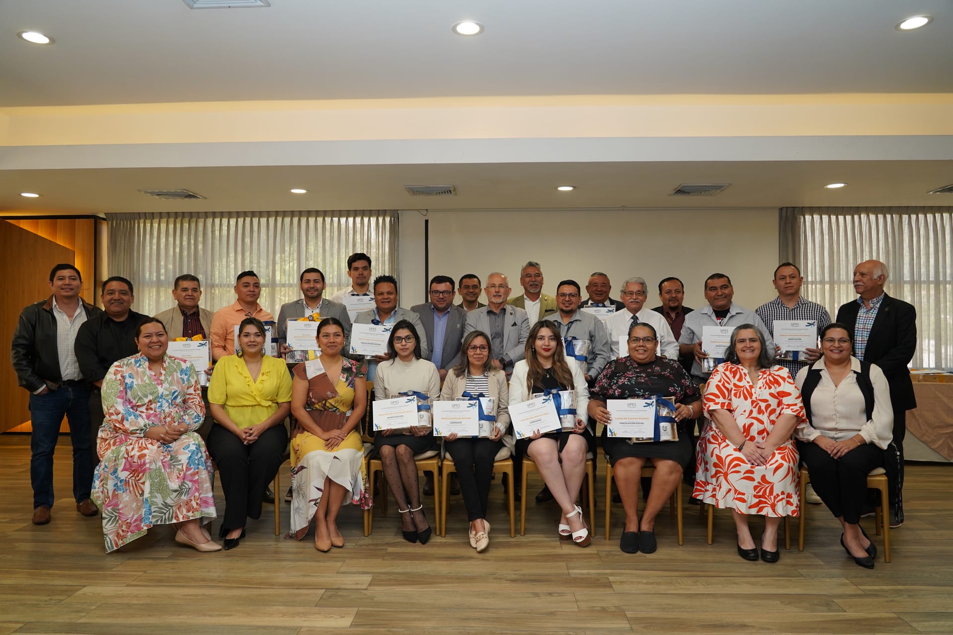 Grupo de colaboradores posando con certificados de reconocimiento institucional